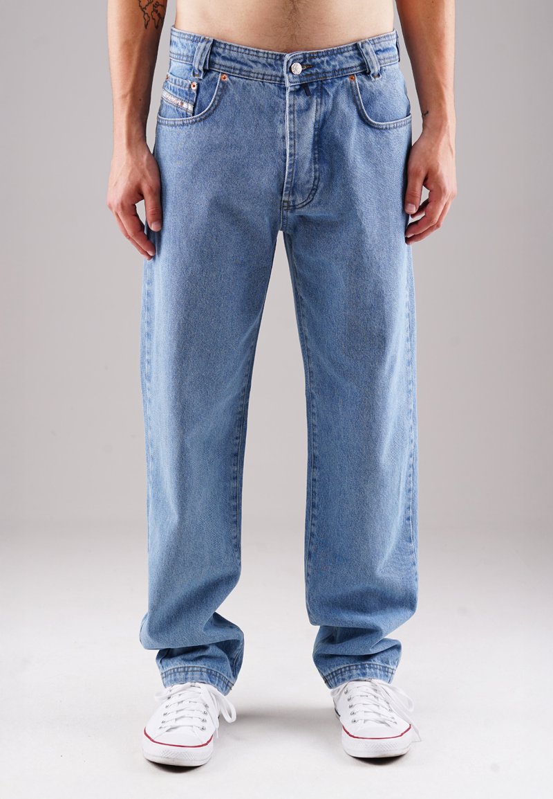 Hellblaue Jeans aus Denim mit lockerer Passform, ausgestattet mit frontalen Taschen, Knopfverschluss und roten Stickdetails an den Taschen.