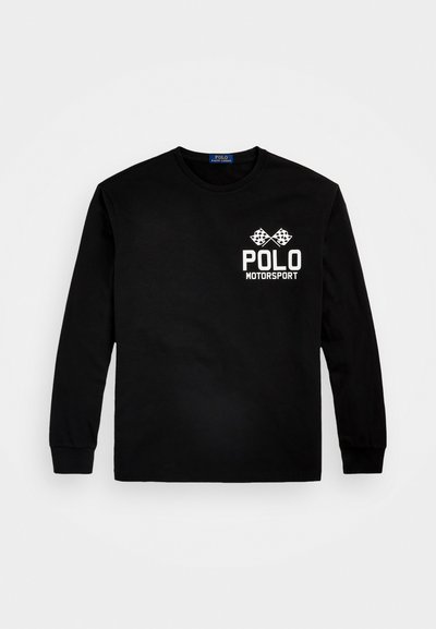 Juodas ilgomis rankovėmis medvilnės marškinėliai. Ant kairiojo krūtinės ploto yra balti užrašai "POLO MOTORSPORT" ir dvi šaškių vėliavos. Apvalus kaklas.