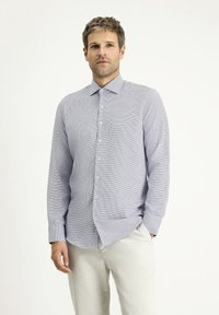 Camicia azzurro chiaro con motivo, realizzata in tessuto lavorato. Presenta un collo con revers, maniche lunghe e bottoni sulla parte anteriore.