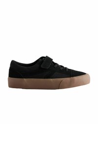 Sneaker nera con upper in canvas, lacci frontali e fascia con chiusura a strappo. Suola in gomma con dettaglio testurizzato in un colore a contrasto.