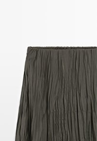 Spódnica plisowana w ciemnoszarym materiale o fakturowanej powierzchni. Posiada elastyczną talię i swobodny fason.