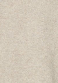 Tissu en tricot beige avec une texture douce, présentant un motif chiné subtil. Le matériau semble léger et extensible, sans aucune pièce métallique visible.