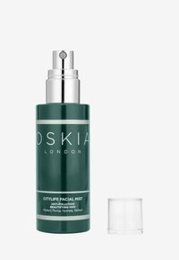 Grøn glas sprayflaske med sølv detaljer, mærket "OSKIA CITYLIFE FACIAL MIST." Klar hætte ved siden af flasken på en hvid baggrund.