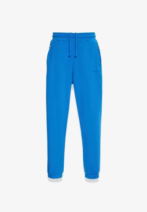 Mėlynos sportinės kelnės, pagamintos iš minkštos medžiagos, su raišteliu liemens dalyje, šoninėmis kišenėmis ir siaurėjančiais rankogaliais. Lygi tekstūra su minimaliu ženklinimu.