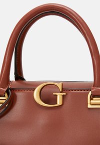 Sac à main en cuir marron avec un logo "G" doré, forme structurée avec deux poignées arrondies et détails de surpiqûres contrastantes.