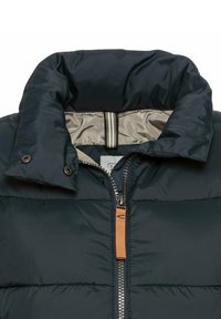 Puffjacke mit hohem Kragen, dunkelblauer Außenseite, hellgrauem Innenfutter, Reißverschluss und einem Reißverschlussschieber aus braunem Leder.