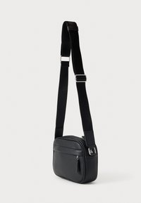 Μαύρο συνθετικό τσαντάκι ώμου με ορθογώνιο σχήμα, κλείσιμο με φερμουάρ και ρυθμιζόμενο ιμάντα. Διαθέτει μπροστινή τσέπη και λεία υφή.