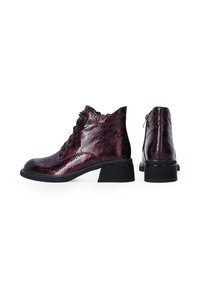 Lace-up ankle boots in a glossy deep red and black finish, featuring a textured surface, a low block heel, and a side zipper.