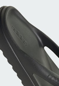 Černé žabky Adidas s texturovanou gumovou podrážkou, hladkým stélkem a vyraženým logem. Design má otevřenou špičku a ergonomický tvar.