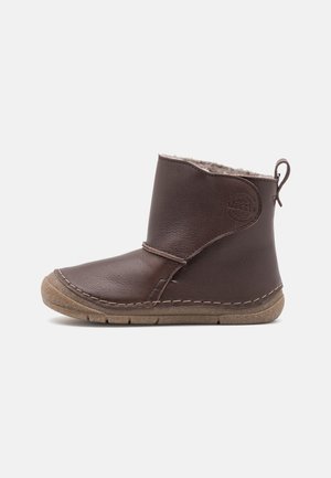 Botte cheville en cuir marron avec semelle en caoutchouc beige, doublure en polaire, languette au talon et couture décorative rosée le long des bords de la semelle.