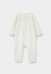 Combinaison en coton blanc pour enfants, à manches longues, fermeture à boutons au dos, et bords de poignets et de chevilles retroussés. Texture lisse, design simple.