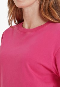 Fuchsia cotton t-shirt with a crew neckline and short sleeves, featuring a smooth texture and relaxed fit.