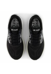 Svarta sportskor med en ventilerande mesh-övre, reflexdetaljer, snörning och en vadderad vit mellansula.