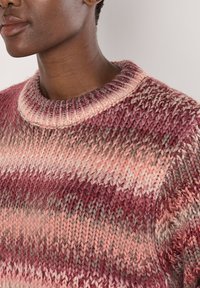 Strickpullover mit runder Ausschnitt, ausgestattet mit mehrfarbigen Streifen in Pink, Rot und Grau. Weiche Textur mit sichtbaren Nähdetails.