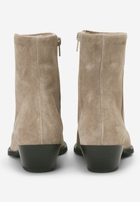 Beżowe zamszowe botki za kostkę o teksturowanej powierzchni, z zamkiem błyskawicznym i czarnym, warstwowym obcasem, charakteryzujące się prostym i eleganckim designem.