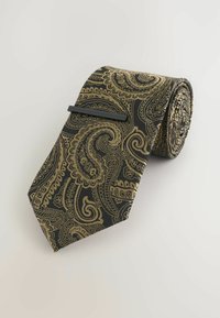 Čierny motýlik so zlatým paisley vzorom, vyrobený z hladkej látky, rolovaný na vystavenie s elegantnou čiernou sponou na ňom.