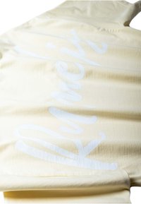 Sweat à capuche couleur crème avec un grand texte blanc stylisé "Awake NY" imprimé en diagonale sur le dos.