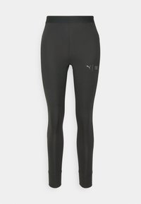 Leggings neri realizzati in materiale elastico, con un design aderente, un'alta vita elastica con il testo "FIRST MILE" e un piccolo logo.