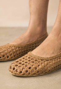 Vävda tan ballerinas med öppen tå-design. Tillverkade av flexibelt material, med en strukturerad yta och dekorativ flätad kant.