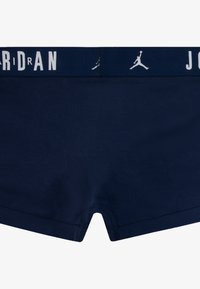 Mørkeblå boxershorts med elastisk talje, der har "JORDAN" brandnavn og logo i hvid. Blødt stof, midt-lår længde, sømløst design.