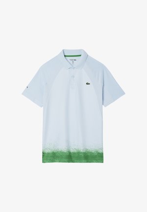 Ljusblå piké med korta ärmar, gröna accenter och ett gradientmönster som övergår till grönt vid fållen. Har en liten logotyp.