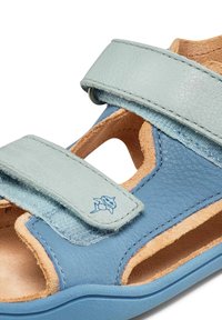 Sandalía azul y celeste hecha de cuero con dos correas ajustables, un diseño abierto y un acabado texturizado en las correas.