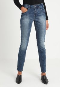 Slim fit niebieskie dżinsy z efektem wyblaknięcia, pięcioma kieszeniami i zapięciem na zamek błyskawiczny. Wykonane z denimu o gładkiej fakturze.