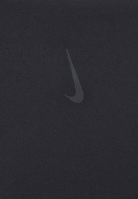 Black athletic fabric with a smooth texture, featuring a prominent black Nike swoosh logo in the center. Simple, minimalist design.
