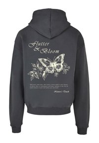 Sort hoodie med en afslappet pasform, der har et stort hvidt sommerfugletryk, blomsterdesigns og tekst på ryggen. Blødt bomuldsstof.