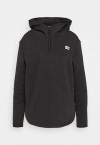 Schwarzer Fleece-Hoodie mit einem halben Reißverschluss-Design, ausgestattet mit einer großen Kapuze, strukturiertem Stoff und einem kleinen Logo auf der Brust.