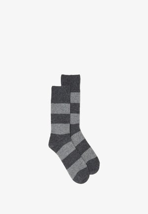Chaussettes rayées en gris foncé et gris clair. Fabriquées en matériau doux avec une texture côtelée. Dotées d'une double épaisseur au niveau du haut.