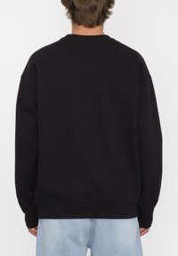 Schwarzer Rundhals-Sweatshirt mit lockerer Passform, gerippten Bündchen und Saum, aus weichem Baumwollmaterial. Einfaches Design ohne sichtbare Logos.