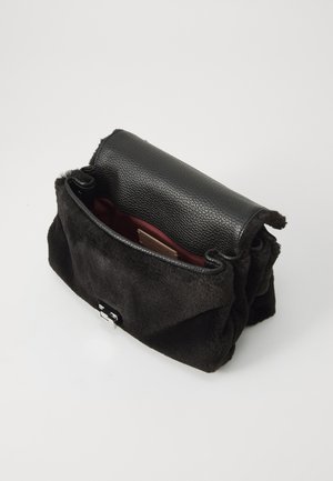 Sac à main noir avec un extérieur en texture ressemblant à de la fourrure, un rabat supérieur en cuir et un intérieur bordeaux. Équipé d'un fermoir en métal argenté à l'avant.