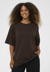 T-shirt marrone a maniche corte realizzato in morbido cotone, caratterizzato da un collo rotondo e una vestibilità comoda, con una texture liscia.