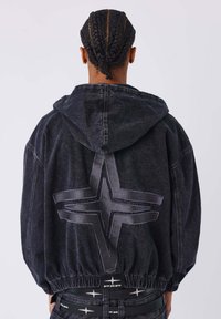 Zwarte denim hoodie met een groot kruisdesign op de achterkant. Voorzien van een capuchon met trekkoord en een elastische zoom voor een ontspannen pasvorm.