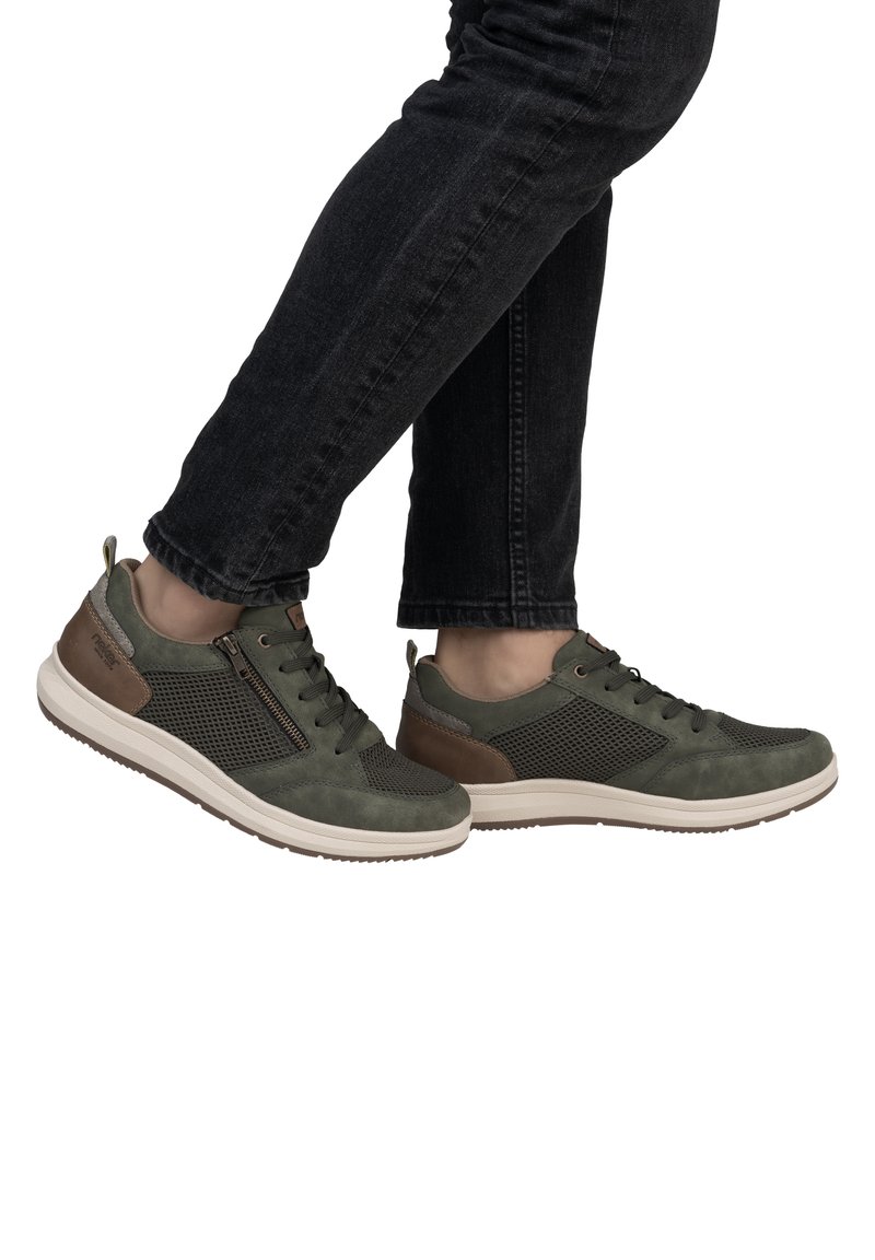 Green athletic shoes with mesh panels, suede accents, and a rubber sole. Features a lace-up design and a side zipper detail.