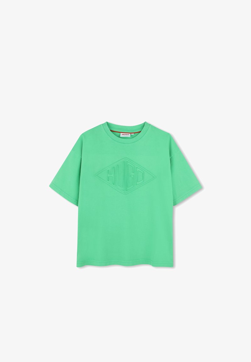 Camiseta de algodón verde con un corte relajado, que presenta un logo texturizado en forma de diamante en el centro. Cuello redondo y mangas cortas.