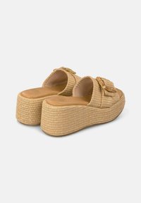 Sandali platform con tomaia intrecciata in materiale simile alla paglia naturale, color beige, ampie cinghie con dettaglio della fibbia e suola testurizzata per una maggiore aderenza.
