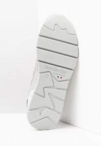 Suela de zapatilla blanca con un patrón texturizado, que presenta la marca "NeroGiardini" y "Hecho en Italia", y un indicador de tamaño de 42.