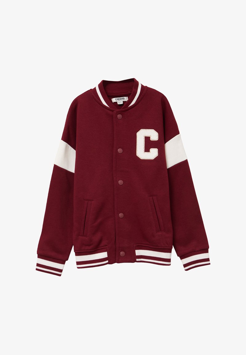 Chaqueta varsity burdeos hecha de algodón, con un emblema blanco en forma de "C", mangas blancas en contraste, bolsillos frontales y puños y dobladillo acanalados a rayas.
