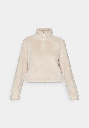 Fleece quarter-zip pullover in lichtbeige, met een hoge kraag, lange mouwen en een trekkoord onderaan. Zachte, gestructureerde stof.