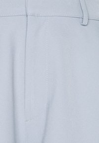 Light blue trousers made from smooth fabric, featuring a straight design with visible stitching and a front pocket detail.