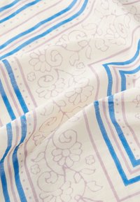 Katoenen stof met een bloempatroon in zacht roze en blauw op een crèmekleurige achtergrond, met gedurfde horizontale en verticale strepen.