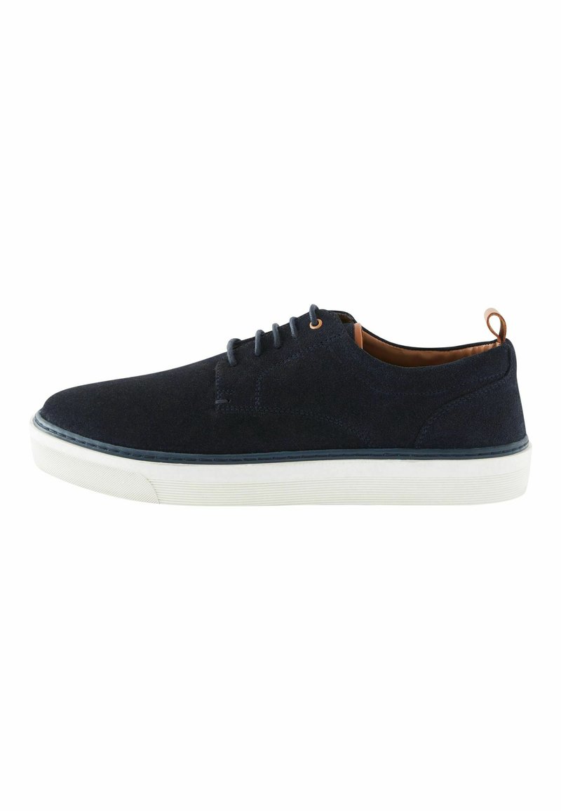 Tumes suede'ist lace-up kingad valge kummist tallaga, millel on pruunid aktsendid ja struktureeritud detailid külgedel, ümmargune nina ja minimalistlik disain.