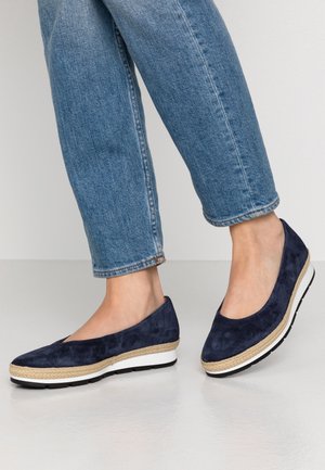 Granatowe zamszowe buty wsuwane z plecioną juty podeszwą środkową i białą gumową podeszwą zewnętrzną. Zaokrąglony nosek i niski klinowy design.