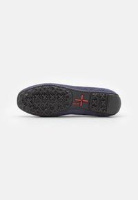 Tumesinine nubukist slip-on kingad, millel on must kummi välistald tekstuuriga ja punane logo detail. Omab ümarat ninaosa ja kontrastset õmblust ääres.