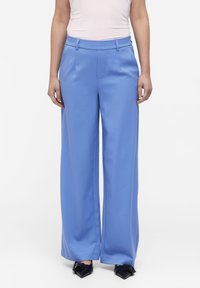 Hellblaue weit geschnittene Hose aus glattem Stoff, mit flachem Bund, Seitentaschen und tailliertem Schnitt in der Taille.