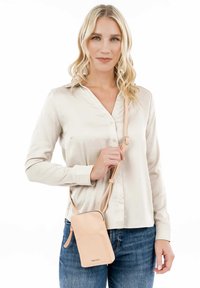 Helles rosa Leder-Umhängetasche mit einem Reißverschluss und verstellbarem Tragegurt, mit einer Vordertasche und glatter Textur.