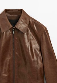 Veste en cuir marron avec un design élégant, un col pointu et une fermeture éclair sur le devant. La surface a une texture lisse et légèrement brillante.