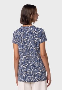 Kortärmad t-shirt i vitt med blå paisleymönster; tillverkad av mjukt material; avslappnad passform med rundad halsringning och rak nederkant.